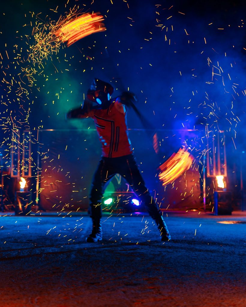 Fire show, dancing with flame, draws a fiery figure in the dark, bright sparks in the night.
